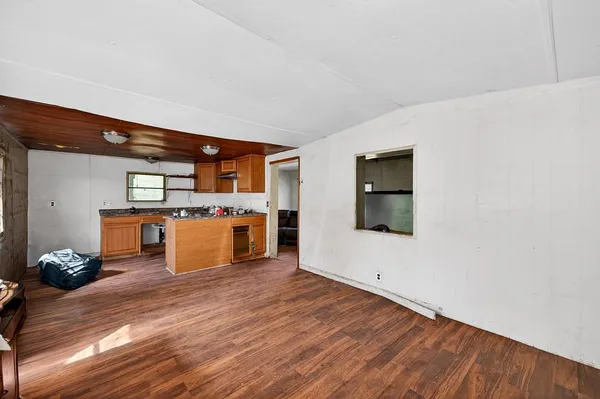 a large white kitchen with wooden floors and a fireplace