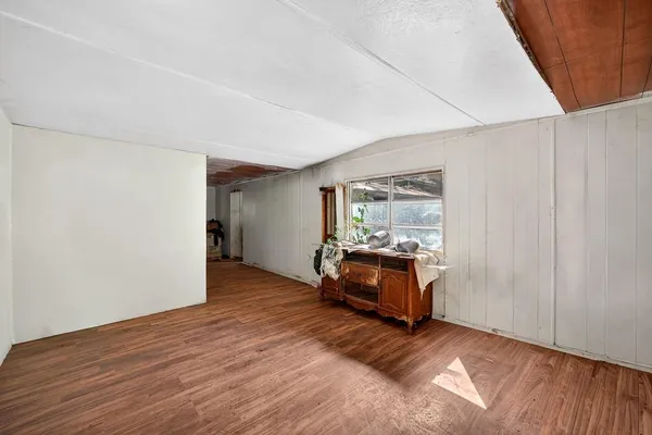 a view of a livingroom with wooden floor and furniture