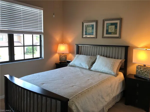 a bed sitting in a bedroom next to a window