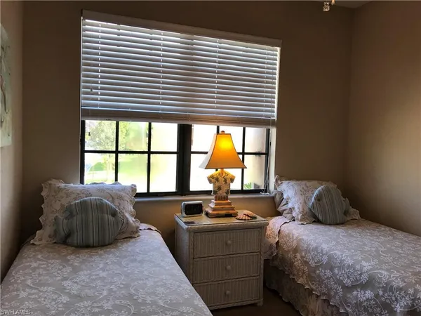 a bedroom with a bed and a large window
