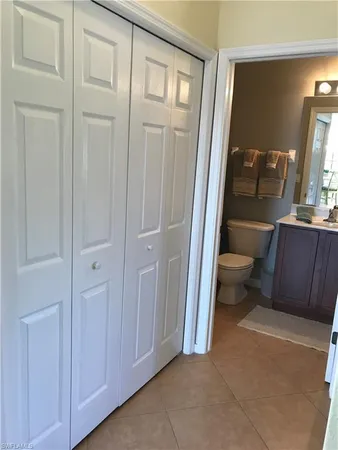 a view of a hallway with wooden floor windows and a bathroom