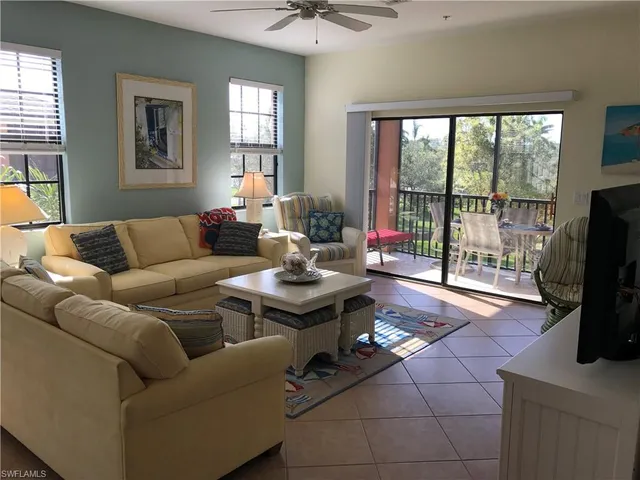 a living room with furniture a flat screen tv and a floor to ceiling window