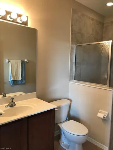 a bathroom with a sink mirror vanity and toilet