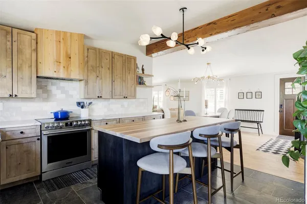 a kitchen with granite countertop a table chairs stove and cabinets