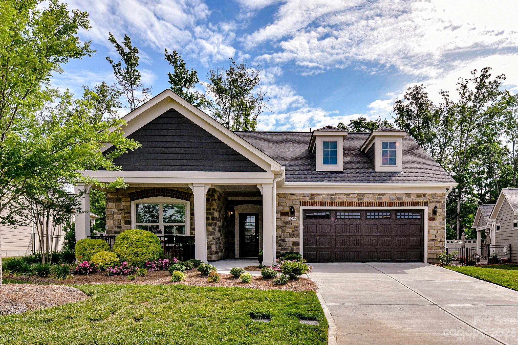 a front view of a house with a yard and potted plants