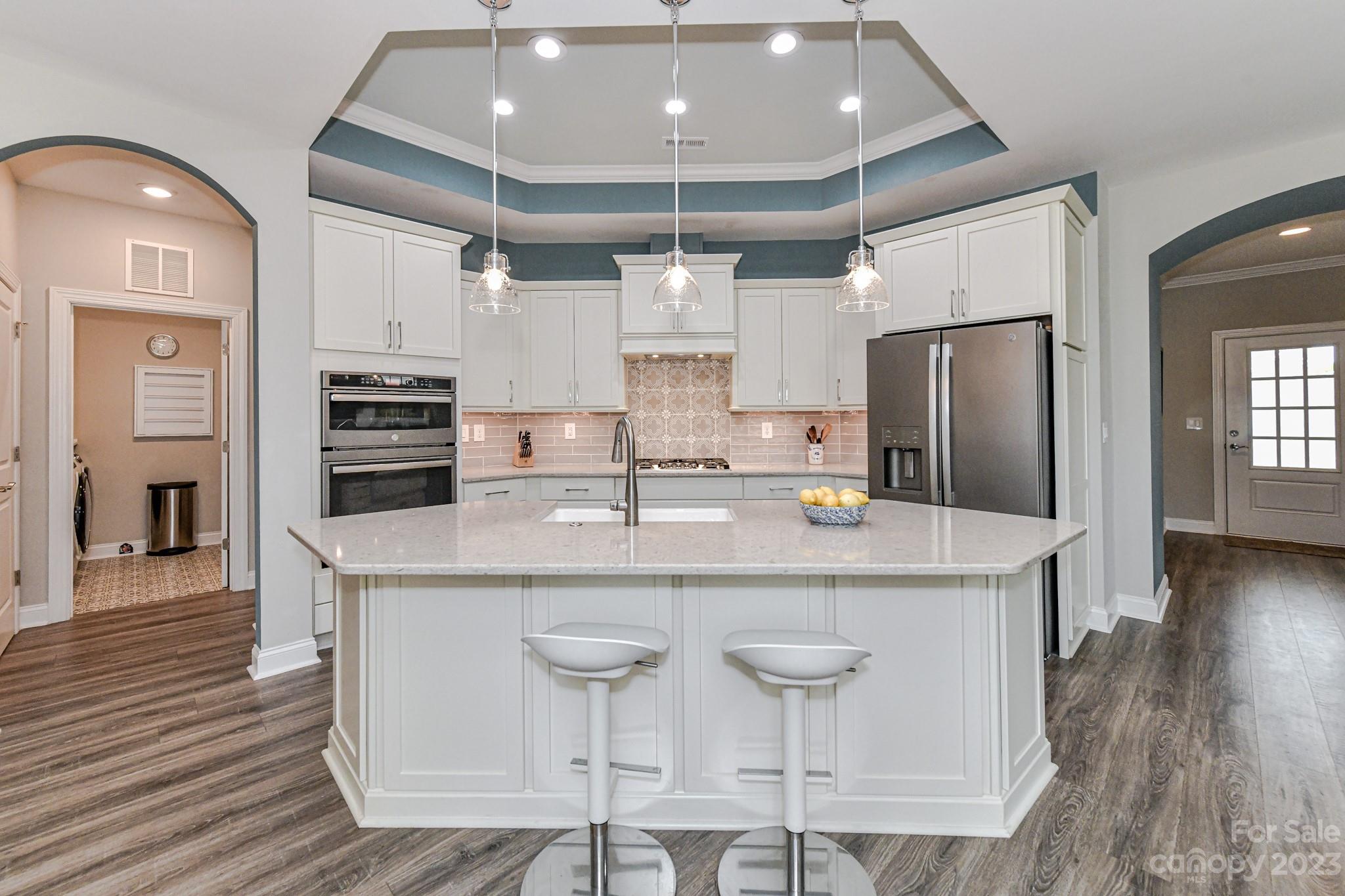 2330 Wesley Landing Road Waxhaw, NC 28173 - Photo 13 of 47 a kitchen with stainless steel appliances kitchen island granite countertop a table chairs refrigerator and microwave