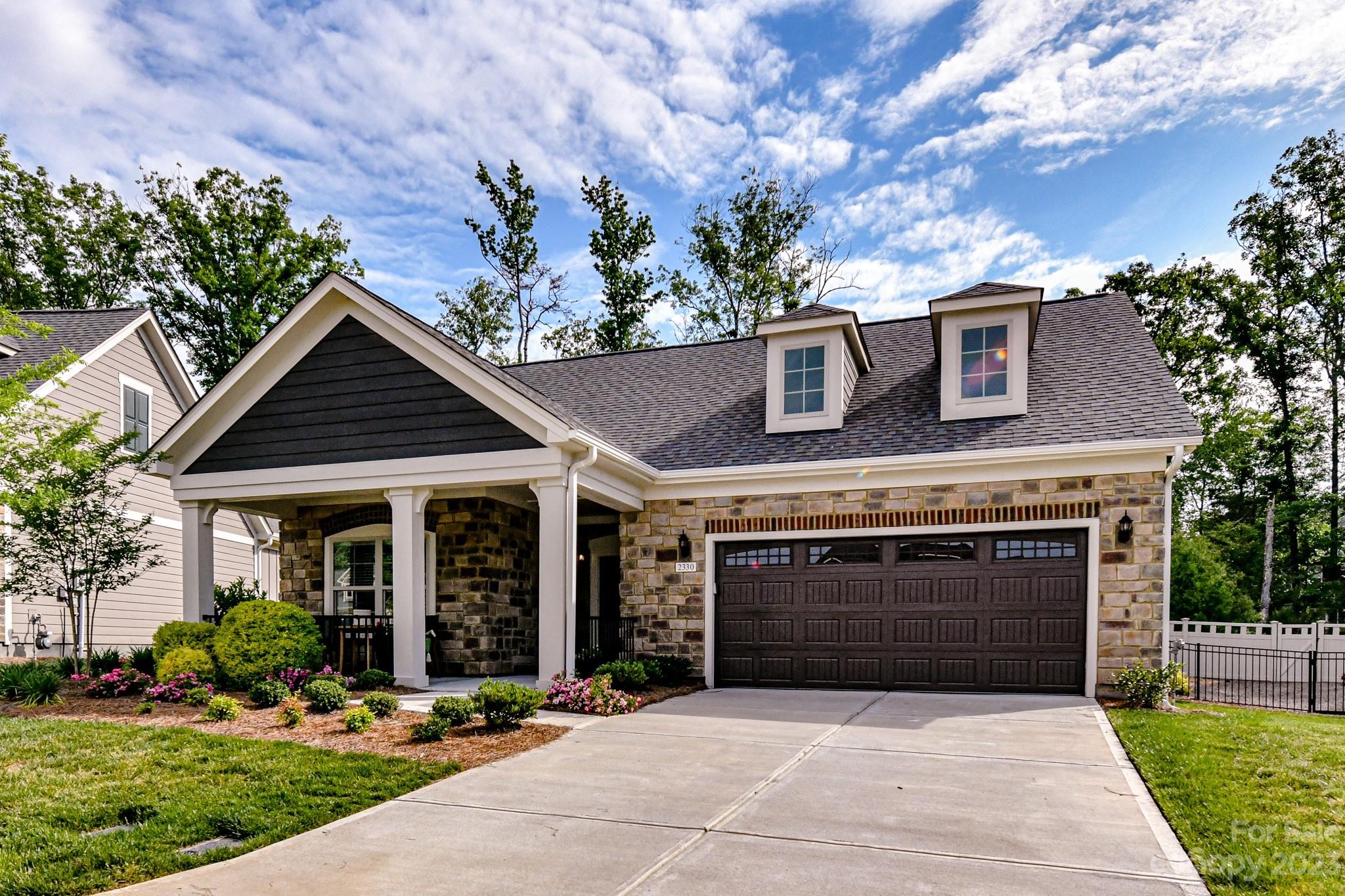 2330 Wesley Landing Road Waxhaw, NC 28173 - Photo 2 of 47 a front view of a house with a garden and plants
