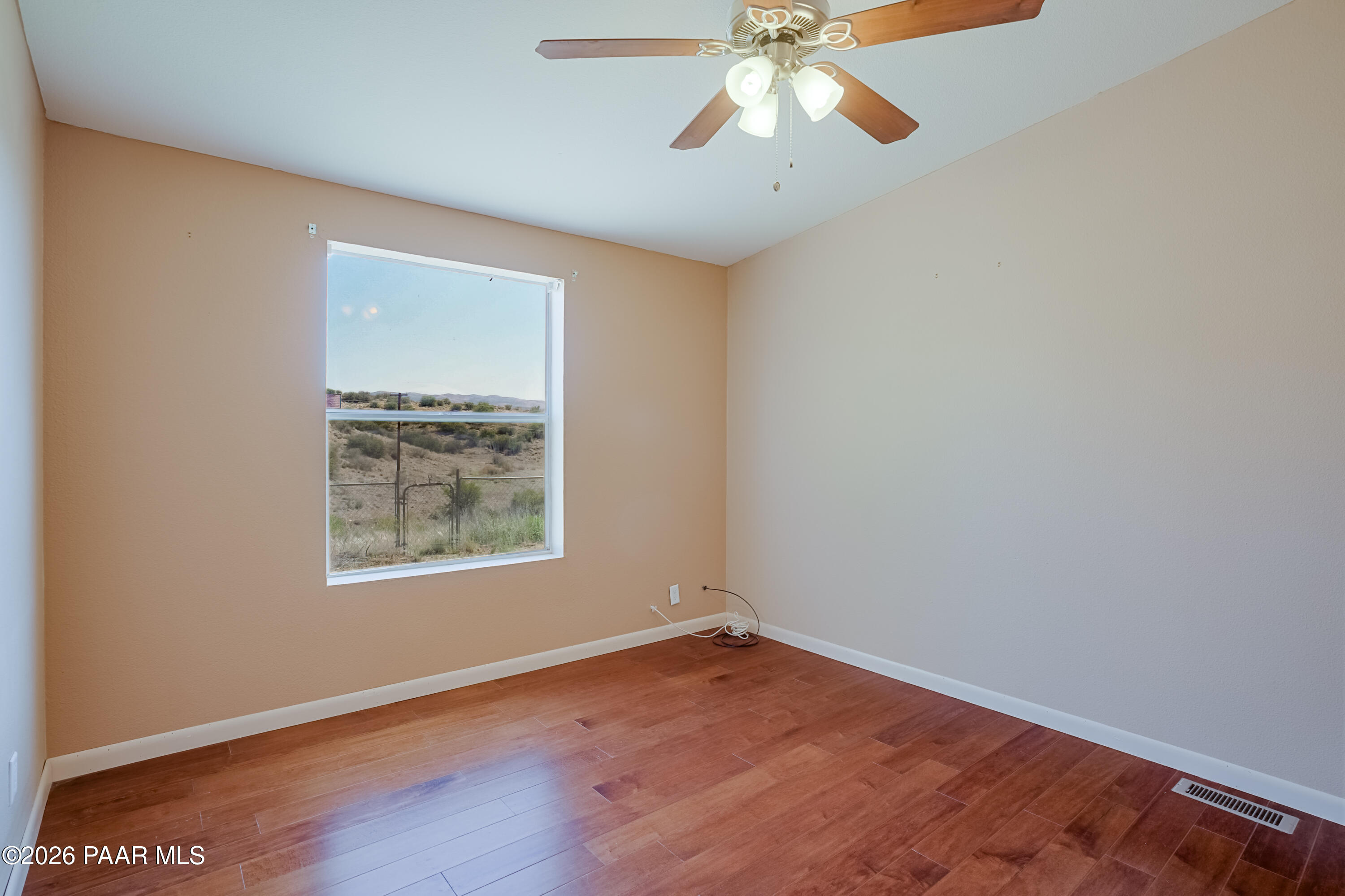 11800 Henderson Road Dewey-Humboldt, AZ 86327 - Photo 16 of 54 an empty room with wooden floor chandelier fan and windows