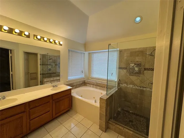 a bathroom with a double vanity sink and mirror with shower