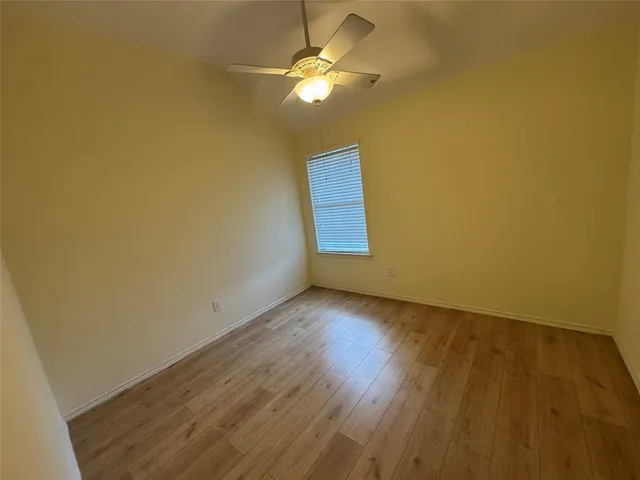 a view of an empty room and chandelier fan