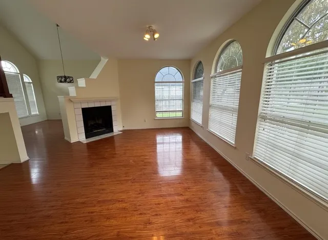 a view of empty room with wooden floor and fireplace