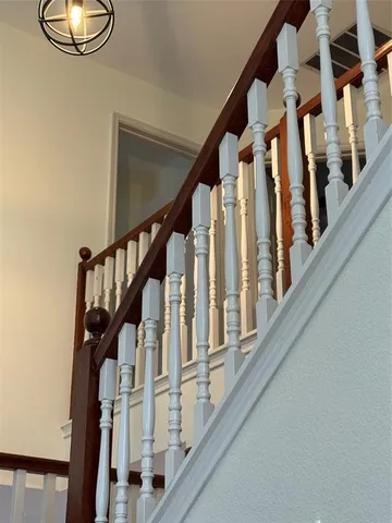 a view of staircase with lots of frames on wall and a window