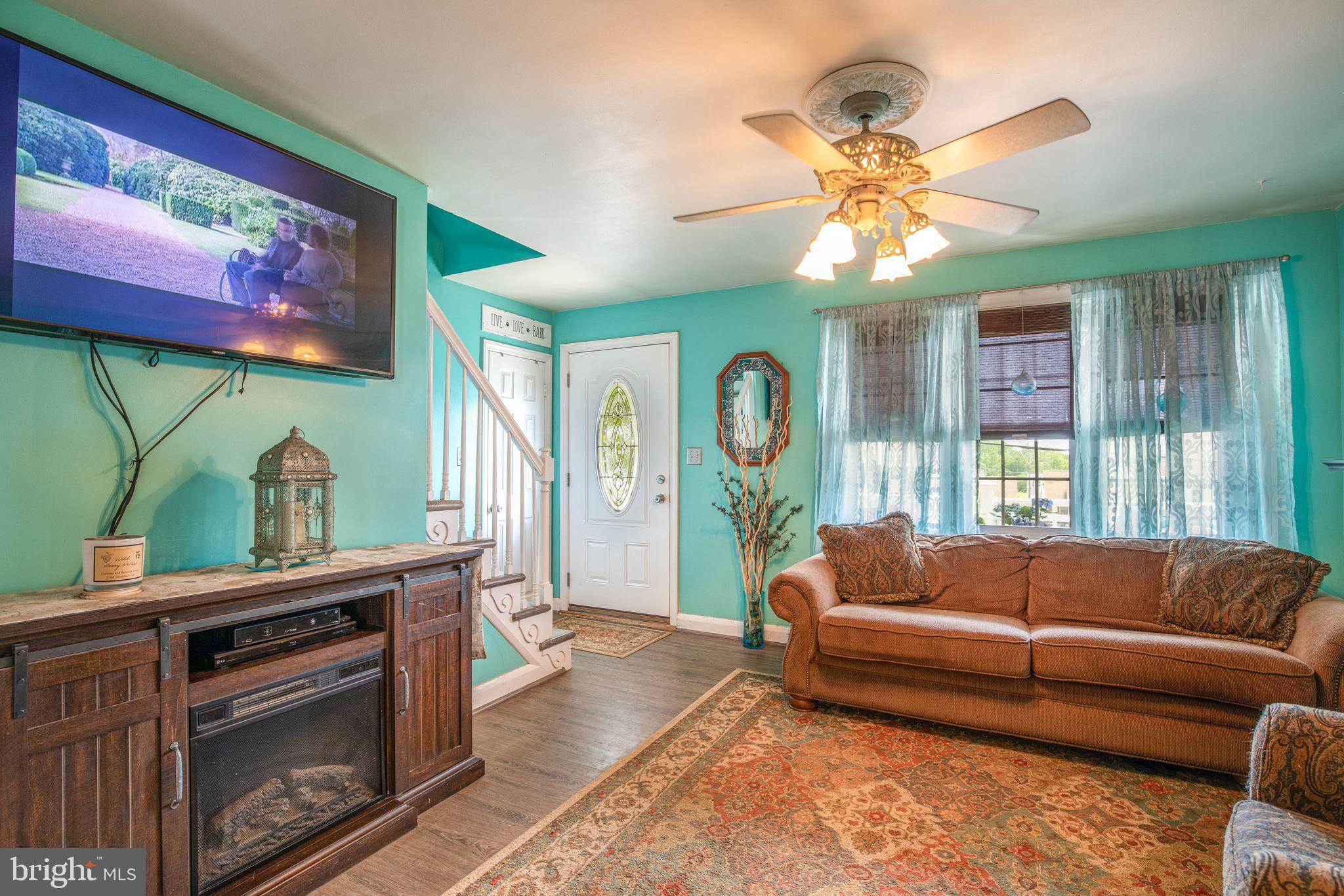 1239 Landover Road Baltimore, MD 21237 - Photo 6 of 13 a living room with furniture a chandelier and a fireplace