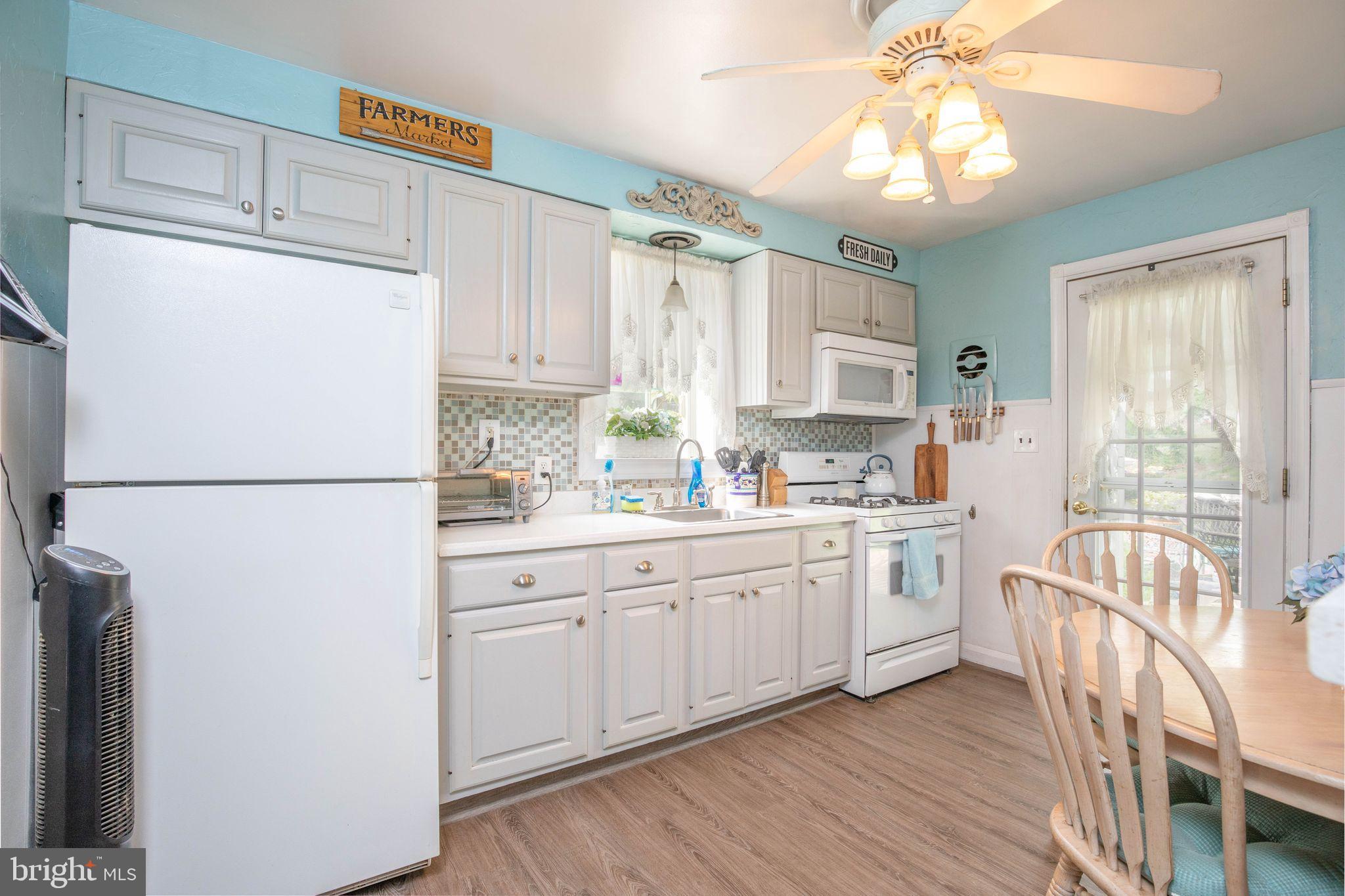 1239 Landover Road Baltimore, MD 21237 - Photo 9 of 13 a kitchen with appliances cabinets a sink and a refrigerator