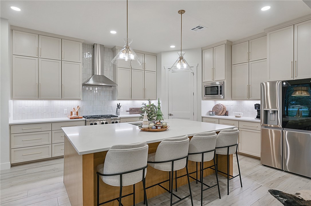 10704 Harvey Ranch Road College Station, TX 77845 - Photo 12 of 18 a kitchen with kitchen island granite countertop a sink a center island stainless steel appliances and cabinets