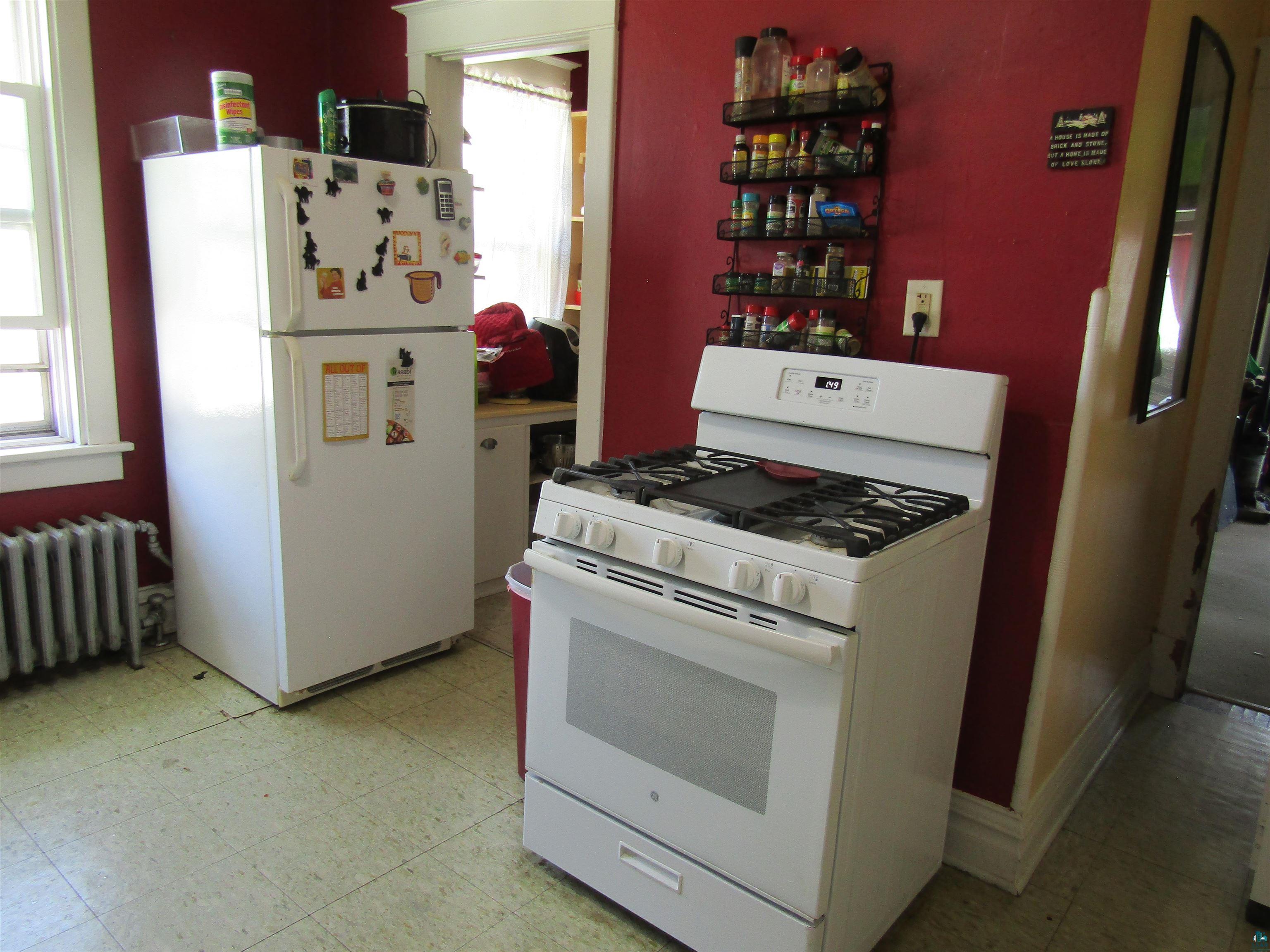 1115 Harrison Street Superior, WI 54880 - Photo 48 of 49 Bright white gas range with griddle feature and digital controls, paired with a matching refrigerator/freezer unit