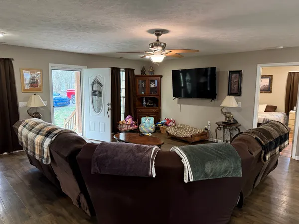 a living room with furniture a flat screen tv and kitchen view