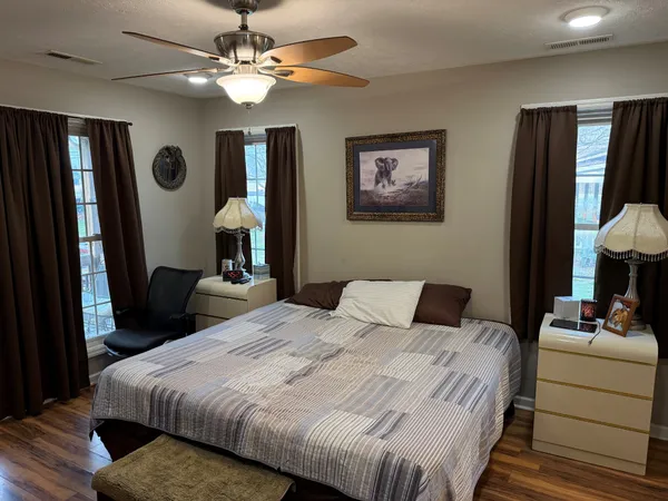 a bedroom with a bed and a lamp on dresser
