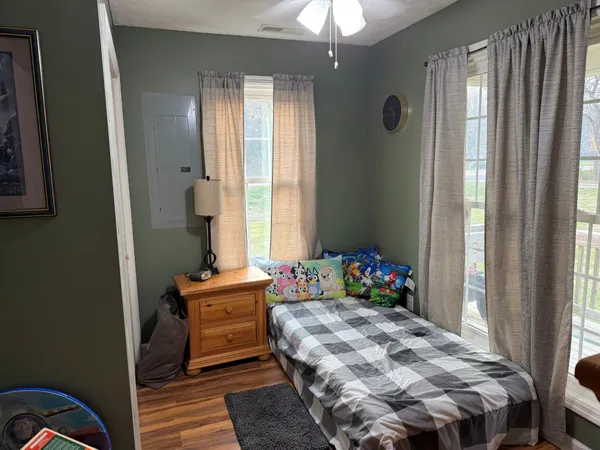 a bedroom with a bed and wooden floor