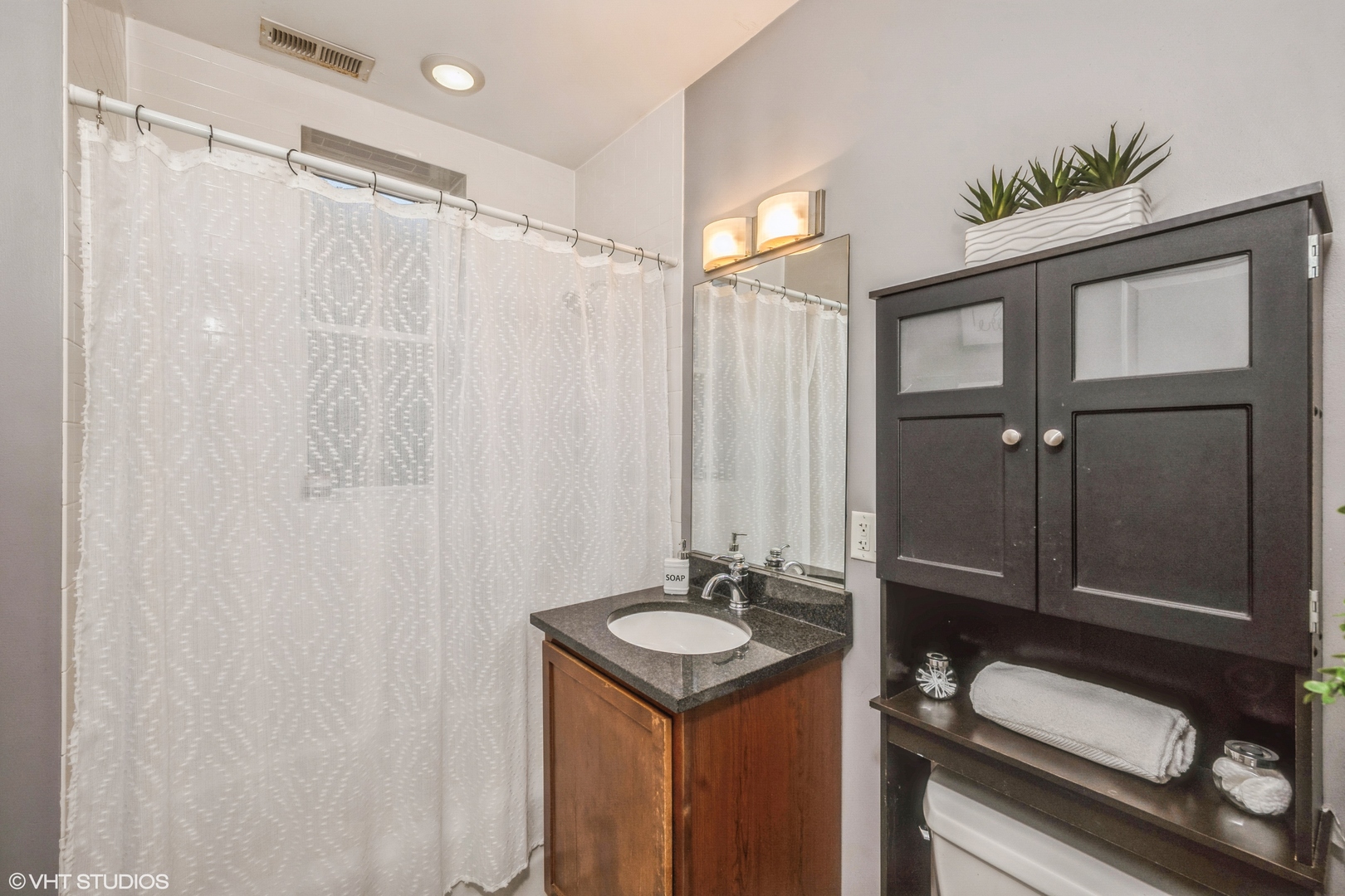 1750 West Rascher Avenue, Unit 2 Chicago, IL 60640 - Photo 9 of 11 a bathroom with a granite countertop sink a mirror and shower