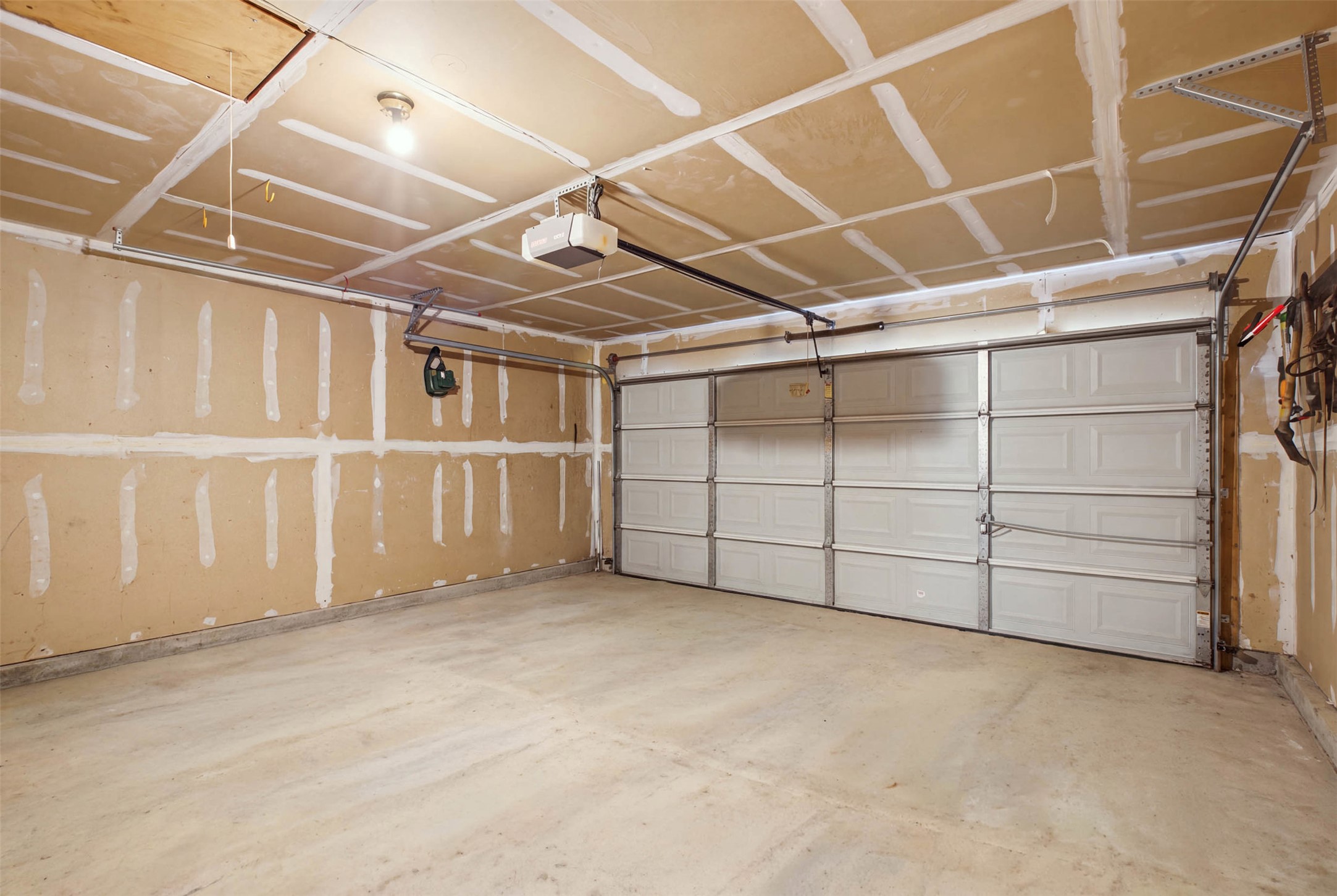 1717 Rendova Lane Pflugerville, TX 78660 - Photo 21 of 32 A spacious, bare garage awaits customization with ample room for vehicles and storage.