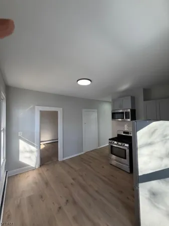 a kitchen with granite countertop a refrigerator and a stove top oven