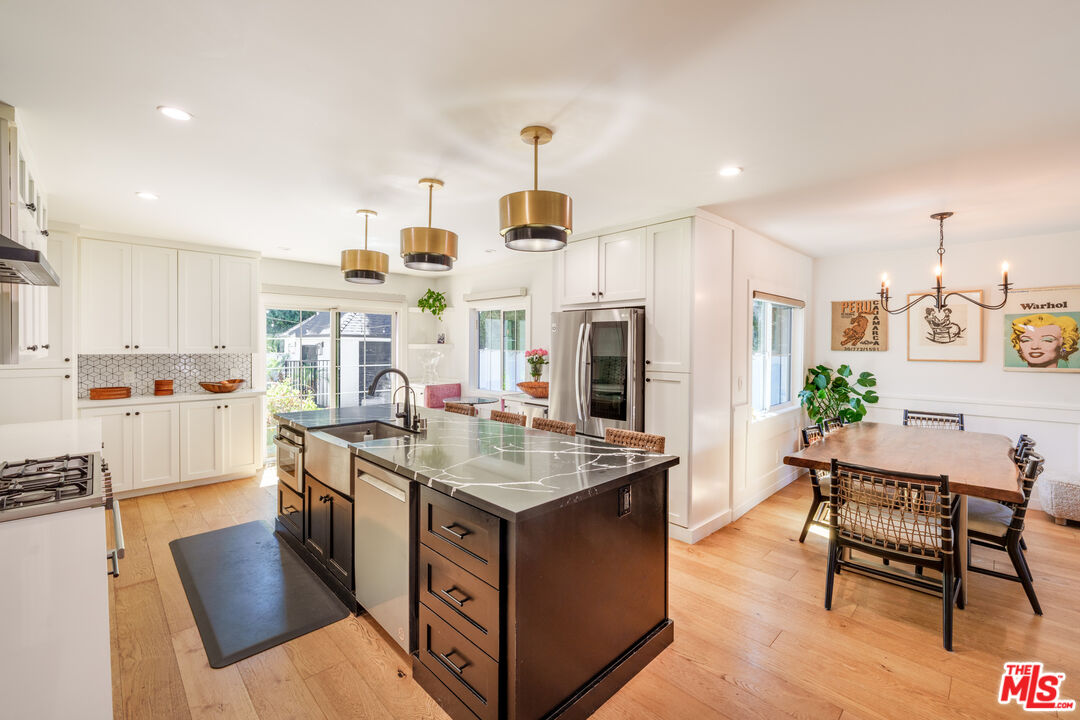 11202 Kling Street North Hollywood, CA 91602 - Photo 5 of 18 a living room with stainless steel appliances kitchen island granite countertop a table chairs and a refrigerator
