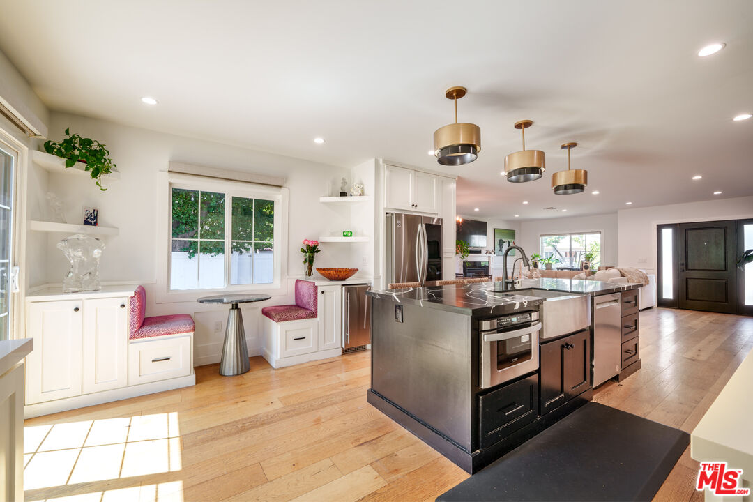 11202 Kling Street North Hollywood, CA 91602 - Photo 6 of 18 a view of kitchen with stainless steel appliances kitchen island granite countertop a stove and a view of living room