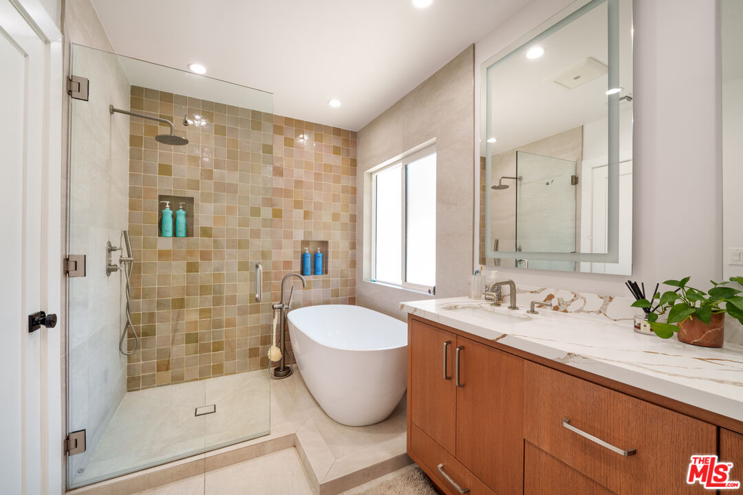 11202 Kling Street North Hollywood, CA 91602 - Photo 8 of 18 a bathroom with a granite countertop sink a toilet a mirror and shower