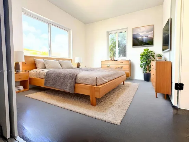 a spacious bedroom with a bed and a flat screen tv