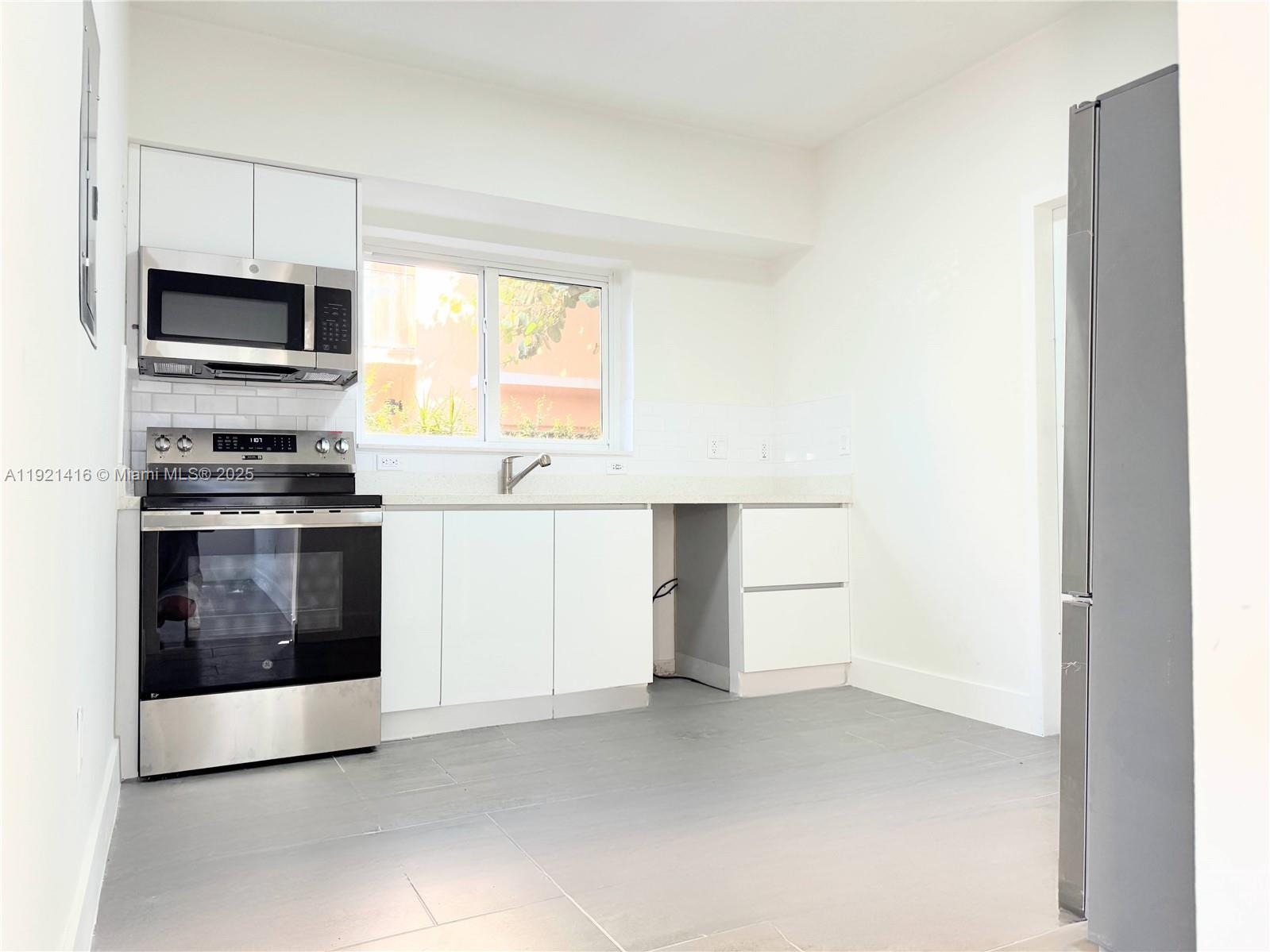 7325 Byron Avenue, Unit 8 Miami Beach, FL 33141 - Photo 10 of 16 a kitchen with a stove and a microwave