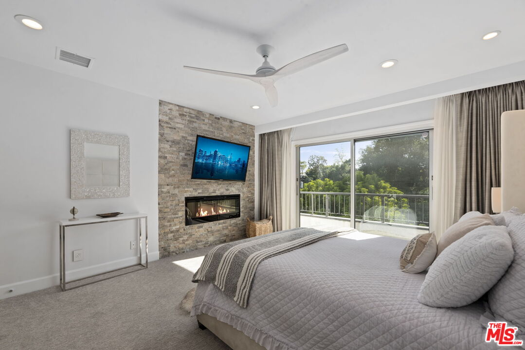 641 Walther Way Los Angeles, CA 90049 - Photo 24 of 53 a bedroom with a bed and a fireplace