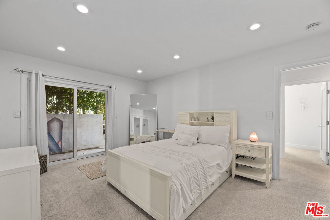 641 Walther Way Los Angeles, CA 90049 - Photo 28 of 53 a spacious bedroom with a large bed and a chandelier