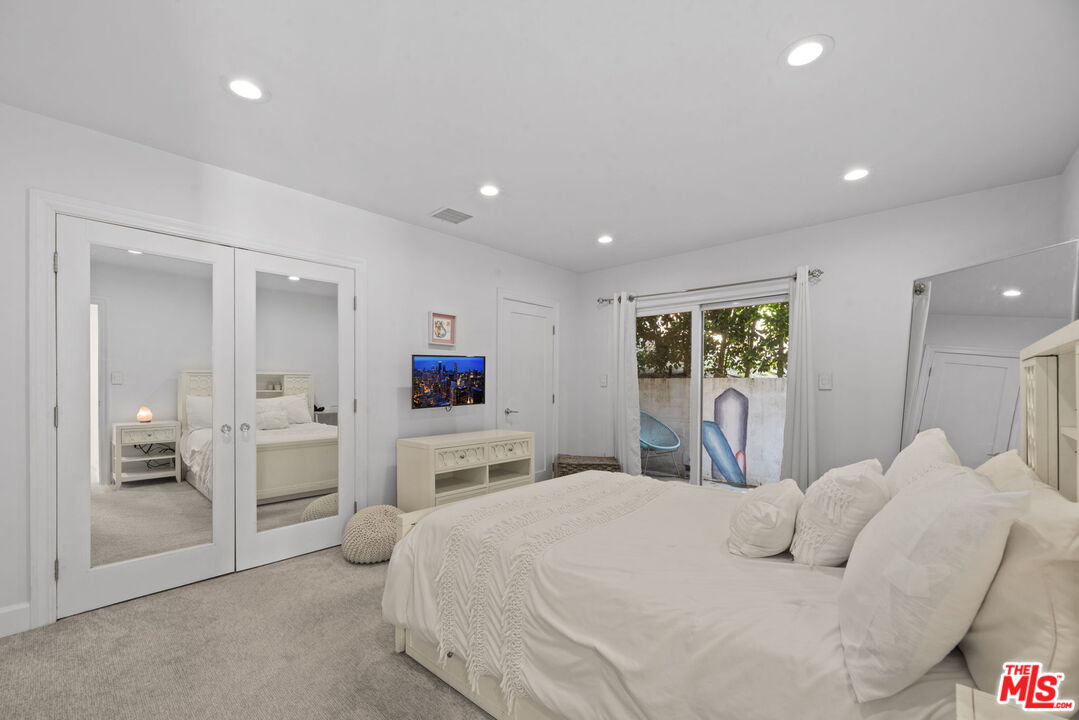 641 Walther Way Los Angeles, CA 90049 - Photo 29 of 53 a bedroom with a bed and a large mirror