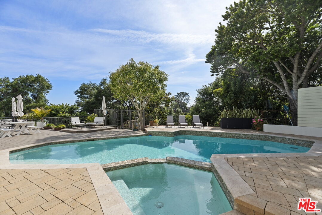 641 Walther Way Los Angeles, CA 90049 - Photo 39 of 53 a view of a swimming pool and trees in the background