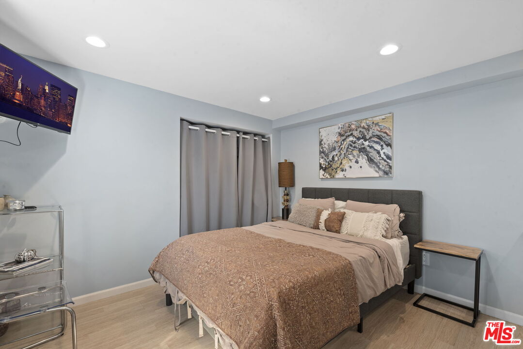 641 Walther Way Los Angeles, CA 90049 - Photo 47 of 53 a bedroom with a large bed and a painting on the wall