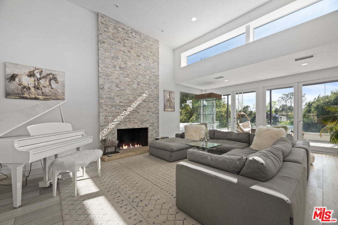 641 Walther Way Los Angeles, CA 90049 - Photo 7 of 53 a living room with furniture a fireplace and a large window