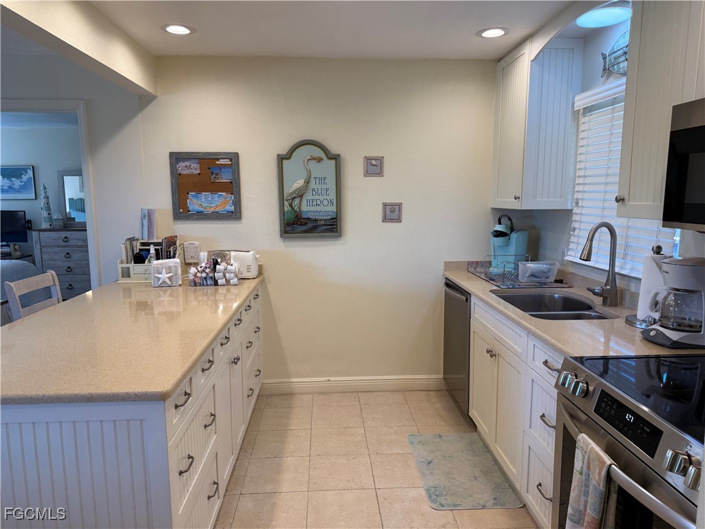 5117 Sea Bell Road, Unit G205 Sanibel, FL 33957 - Photo 11 of 31 a kitchen with a sink stove and cabinets