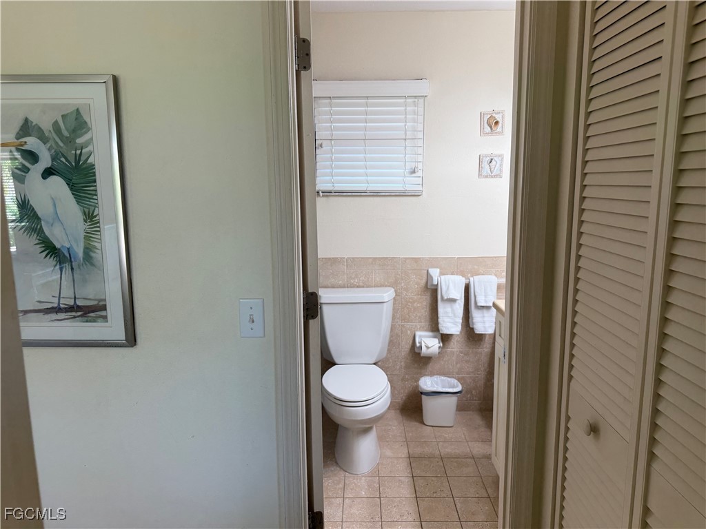 5117 Sea Bell Road, Unit G205 Sanibel, FL 33957 - Photo 22 of 31 a bathroom with a toilet and a shower curtain