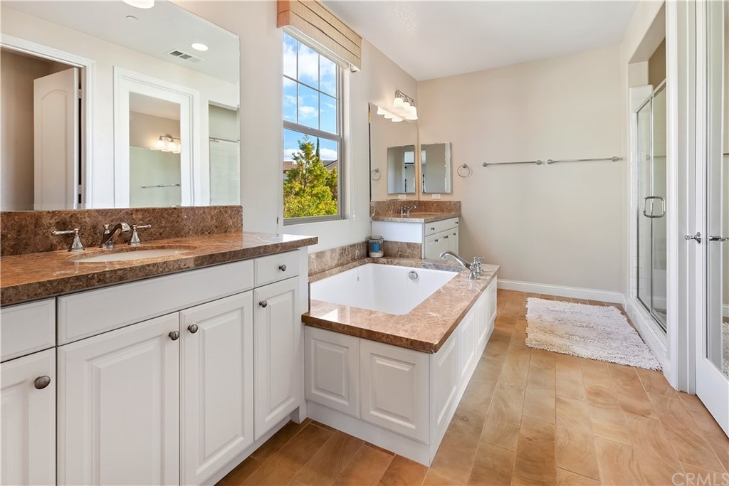 95 Shadowbrook Irvine, CA 92604 - Photo 8 of 23 a bathroom with a granite countertop sink a mirror and a bathtub