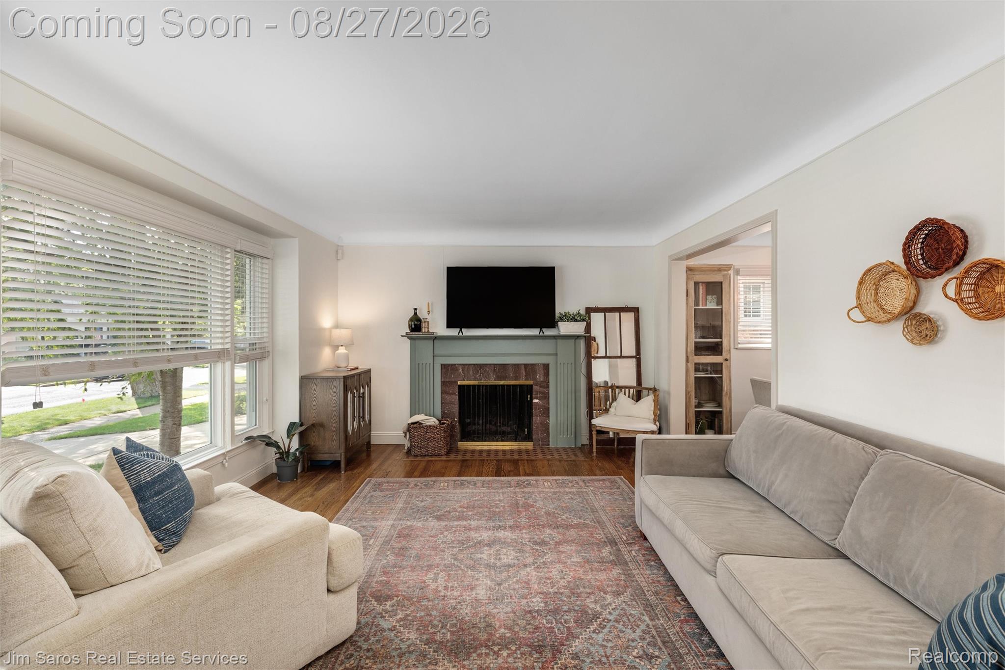 276 Moran Road Grosse Pointe, MI 48236 - Photo 8 of 23 Living area featuring wood-finish flooring, a fireplace with a painted mantel, and an open doorway