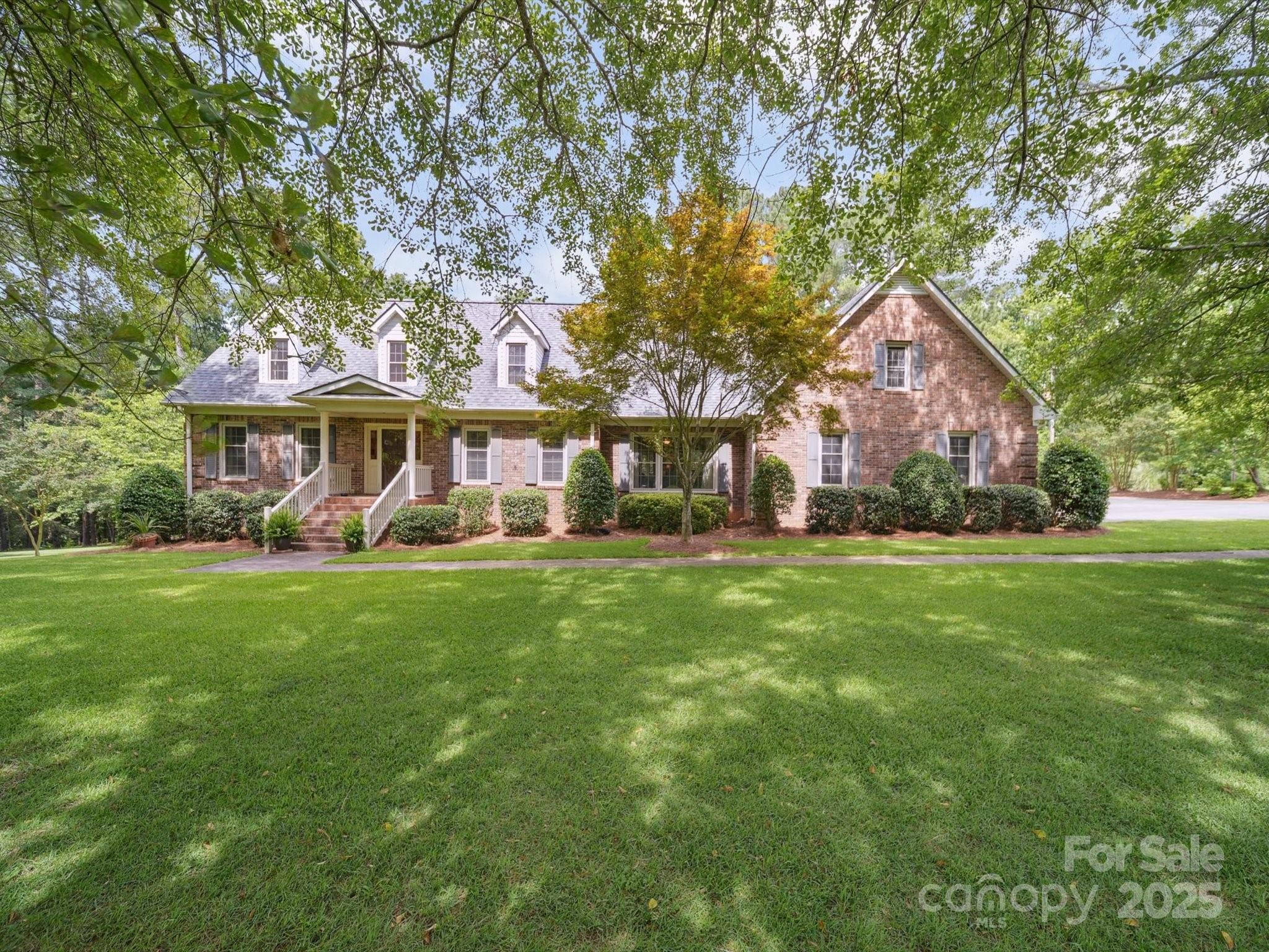 a front view of a house with yard and green space