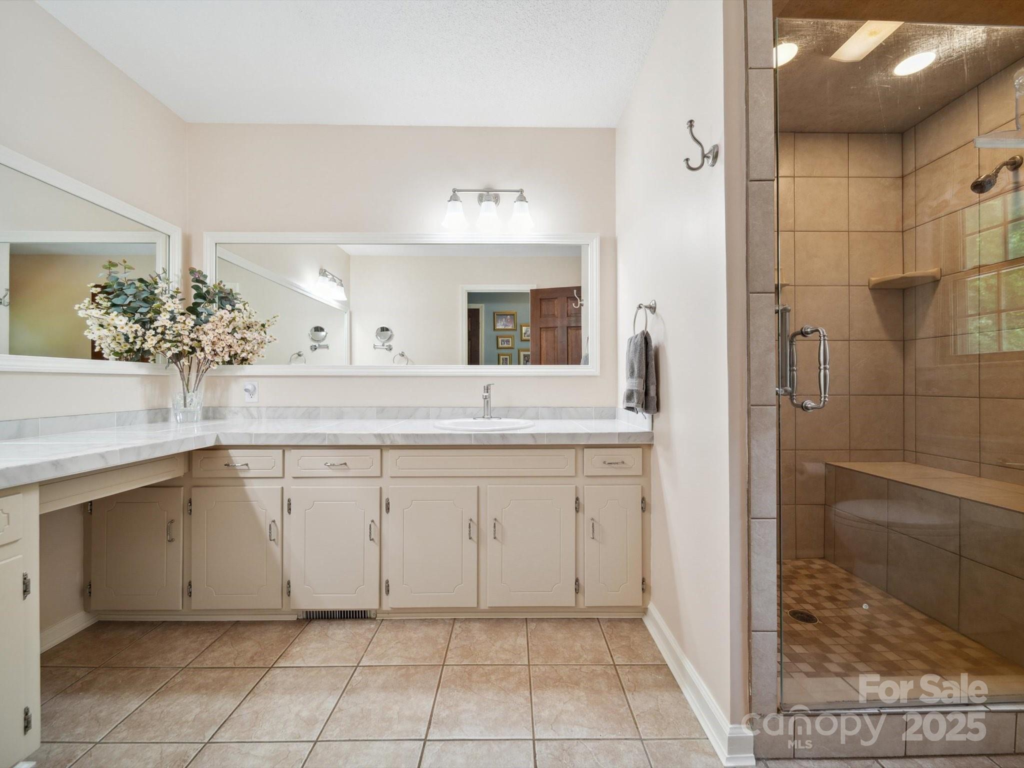 394 Gold Mine Road Wadesboro, NC 28170 - Photo 19 of 39 a spacious bathroom with a granite countertop sink a mirror and a shower