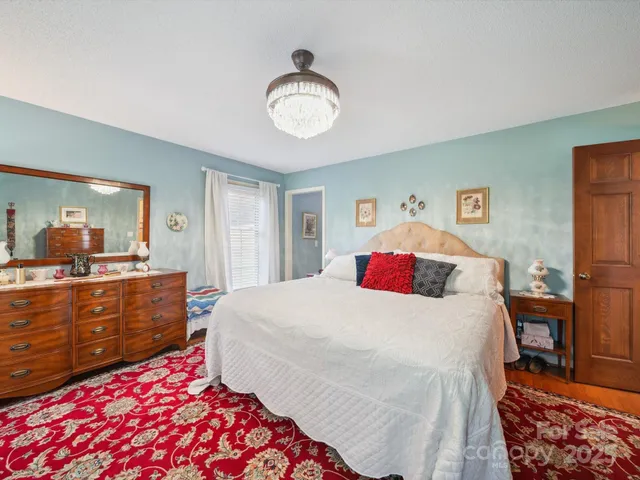 a bedroom with a bed and a chandelier