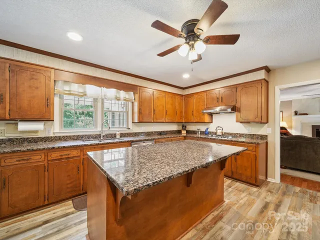 a kitchen with stainless steel appliances granite countertop sink stove and refrigerator