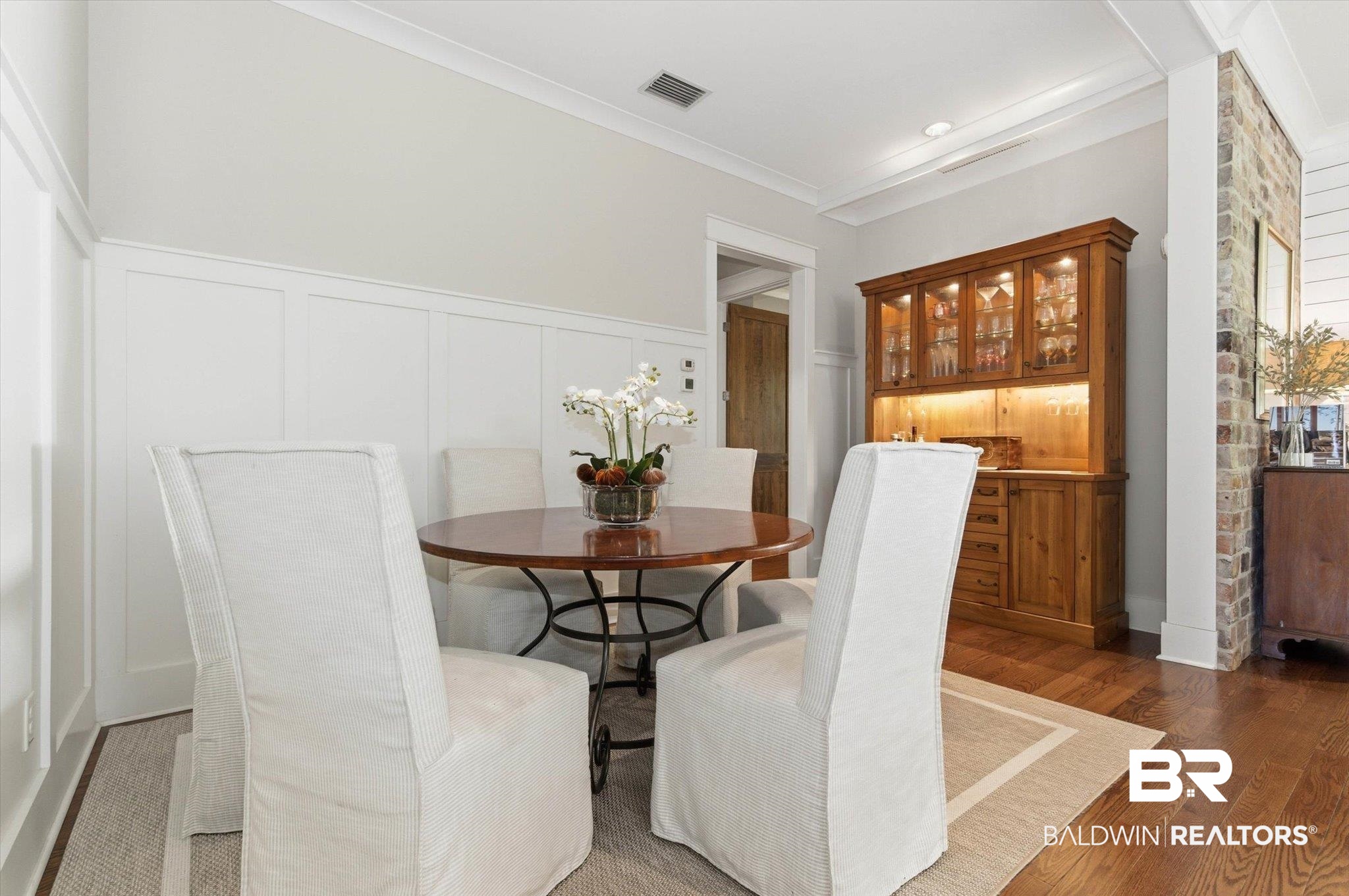 3704 Stein Street Mobile, AL 36608 - Photo 7 of 37 Dining space featuring a decorative wall, a wainscoted wall, dark wood-style flooring, and crown molding