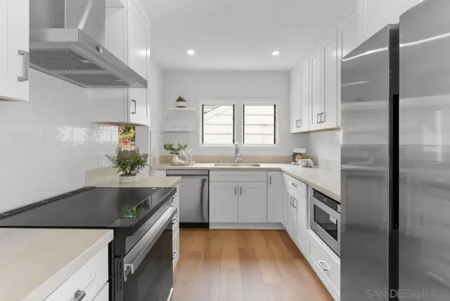 a kitchen with granite countertop a sink stainless steel appliances and cabinets