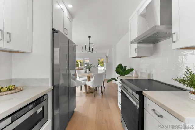a kitchen with granite countertop a sink appliances and cabinets