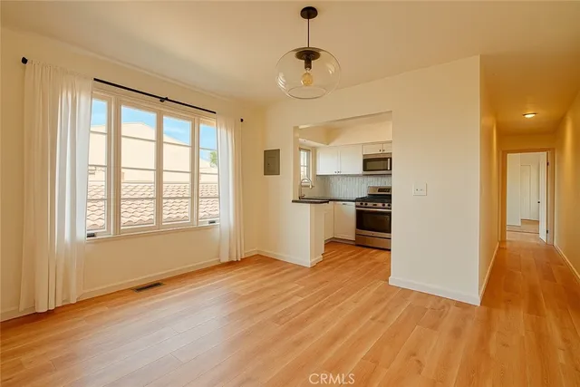 a view of empty room with wooden floor and window