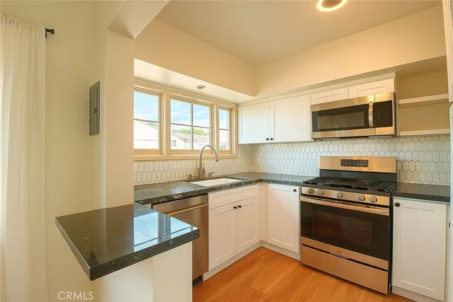 a kitchen with stainless steel appliances granite countertop a stove and a microwave